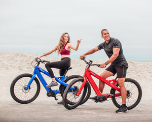 Couple on a fitness bike ride on the beach with the Radiant Carbon